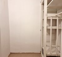 Stauraum mit weißen Regalen in einer 2-Zimmer-Wohnung, mit einem Teppichboden.