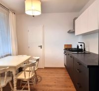 Küche in einer 2-Zimmer-Wohnung mit Essecke und Boden in Holzoptik.