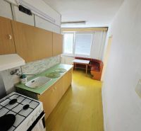 Küche in einer 3-Zimmer-Wohnung mit einfacher Ausstattung, Holzschränken und Essecke.