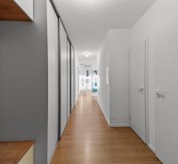 Flur in einer 4-Zimmer-Wohnung mit Holzboden und Stauraum.