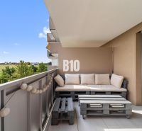 Ein Balkon in einer 4-Zimmer-Wohnung mit Blick auf die Umgebung von Nitra und einer Sitzgelegenheit aus Palettenholz.