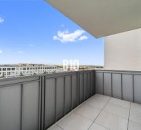 Der Balkon einer 4-Zimmer-Wohnung in Nitra mit Blick auf moderne Bebauung.