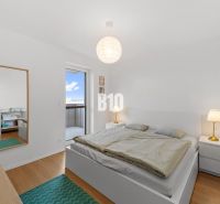 Helles Schlafzimmer mit Holzboden und Zugang zum Balkon in einer 4-Zimmer-Wohnung.