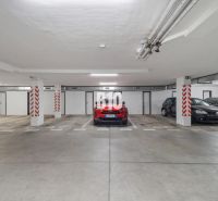 Unterirdische Garage mit geparkten Autos in einer 4-Zimmer-Wohnung in Nitra, Betonboden.