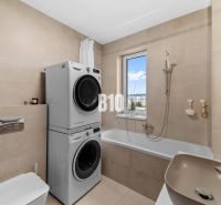 Badezimmer mit Dusche, Waschmaschine und Trockner in einer 4-Zimmer-Wohnung, einfaches Design.