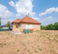 Ein Einfamilienhaus in Nitra mit rotem Dach, umgeben von einem großen Hof und viel Grün.