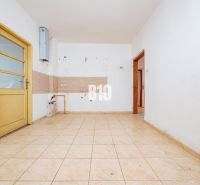 Leerer Raum mit Fliesen und gelber Tür in einem Einfamilienhaus.