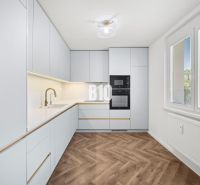 Eine Küche mit moderner Ausstattung und einem Boden in Holzoptik in einer 3-Zimmer-Wohnung.