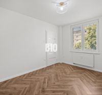 Ein Zimmer in einer 3-Zimmer-Wohnung mit einem Boden in Holzoptik und einem großen Fenster.