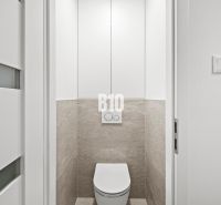 Toilette mit weißen Türen und Fliesen in einer 3-Zimmer-Wohnung.
