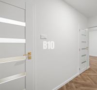 Weiße Inneneinrichtung einer 3-Zimmer-Wohnung mit Holzboden und eleganten Türen.