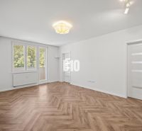 Ein geräumiger Raum mit einem Holzboden in einer 3-Zimmer-Wohnung.