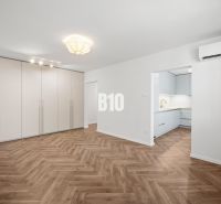 Wohnzimmer in einer 3-Zimmer-Wohnung mit Holzboden und Einbauschrank.