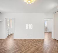 Ein Zimmer in einer 3-Zimmer-Wohnung mit einem Boden in Holzoptik und Einbauschränken.