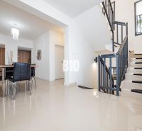 Innenraum eines Einfamilienhauses mit Esstisch und Treppe, Boden mit glänzender Oberfläche.