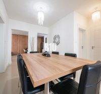 Esszimmer in einem Einfamilienhaus mit großem Tisch und schwarzen Stühlen.