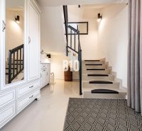 Die Treppe und die weißen Möbel verleihen dem Einfamilienhaus ein Gefühl von Luftigkeit und Stil.