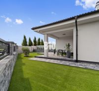 Rasenhof und Terrasse eines Einfamilienhauses in Nitra mit Gartenmöbeln.