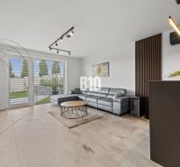 Wohnzimmer mit Ledersofa und Fenstern zur Terrasse in einem Einfamilienhaus.