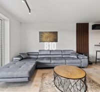 Graues Sofa, runder Tisch und Bild im Wohnzimmer eines Einfamilienhauses.