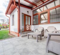 Einfamilienhaus in Nitra mit einem Gartenbereich auf einer gepflasterten Terrasse, Raum für Entspannung.
