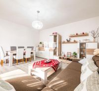 Wohnzimmer mit Esstisch, Holzboden und braunem Sofa in einem Einfamilienhaus.