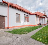 Ein Einfamilienhaus in Nitra mit rotem Dach, Hof und einfacher Gartengestaltung.