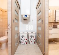 Badezimmer und Toilette im Einfamilienhaus mit Fliesenboden und Schiebetüren.