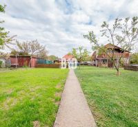 Der Garten des Einfamilienhauses in Nitra mit Rasen und Gehweg.