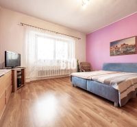 Schlafzimmer im Einfamilienhaus mit Holzboden, Möbeln und Fernseher.