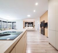 Eine Küche in einem Einfamilienhaus mit einem Boden in Holzoptik und moderner Ausstattung.