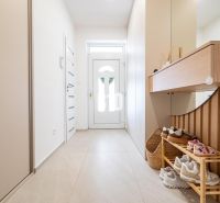 Interieur eines Einfamilienhauses mit einem hellen Flur, einem Schuhschrank und einem Spiegel.