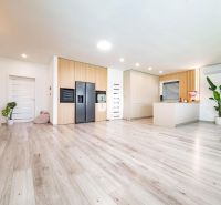 Innenraum eines Einfamilienhauses mit Holzboden und moderner Küche.
