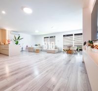 Ein geräumiges Wohnzimmer mit Holzdekorboden und großer Sitzgelegenheit in einem Einfamilienhaus.