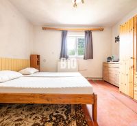 Schlafzimmer im Einfamilienhaus mit Holzmöbeln und Teppich.