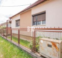 Ein Einfamilienhaus in Nitra mit einem Zaun neben Elektroinstallationen und Vegetation auf dem Grundstück.