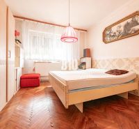 Ein Schlafzimmer in einem Einfamilienhaus mit einem Holzboden und Vintage-Accessoires.
