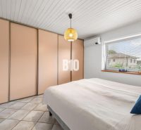 Schlafzimmer im Einfamilienhaus mit großem Einbauschrank, Klimaanlage und Fenster.