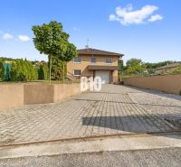 Ein Einfamilienhaus in Nitra mit gepflasterter Zufahrt und gepflegtem Garten.