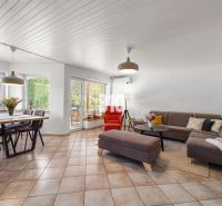 Ein geräumiges Wohnzimmer in einem Einfamilienhaus mit einem Esstisch und einem bequemen Sofa.