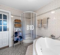 Badezimmer im Einfamilienhaus mit Badewanne, Dusche und Handtuchregal.