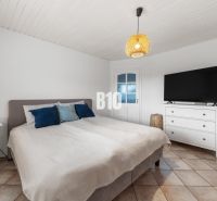Schlafzimmer im Einfamilienhaus mit Bett, Fernseher und Nachttisch.