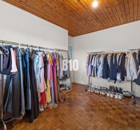 Ein Kleiderschrank im Einfamilienhaus mit Kleiderstangen und einem Boden in Holzoptik.