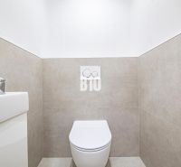 Badezimmer in einer 3-Zimmer-Wohnung mit WC und Waschbecken, einfache Fliesen an den Wänden.