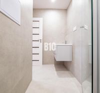 Badezimmer in einer 3-Zimmer-Wohnung mit einfachem Design und einem hängenden Waschbecken.