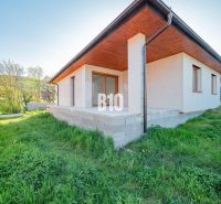Ein Einfamilienhaus in Nitra mit einer Betonterrasse und einem grünen Rasen im Garten.
