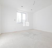 Ein leerer Raum mit weißen Wänden und Betonboden in einem Einfamilienhaus.