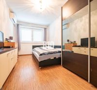 Schlafzimmer in einem Einfamilienhaus mit Holzboden, Schrank und Fernseher.