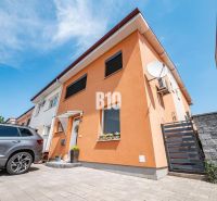 Ein Einfamilienhaus in Nitra mit einer orangefarbenen Fassade und einem Auto im Hof.