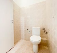 Badezimmer in einer 2-Zimmer-Wohnung mit beigen Fliesen und Toilette.